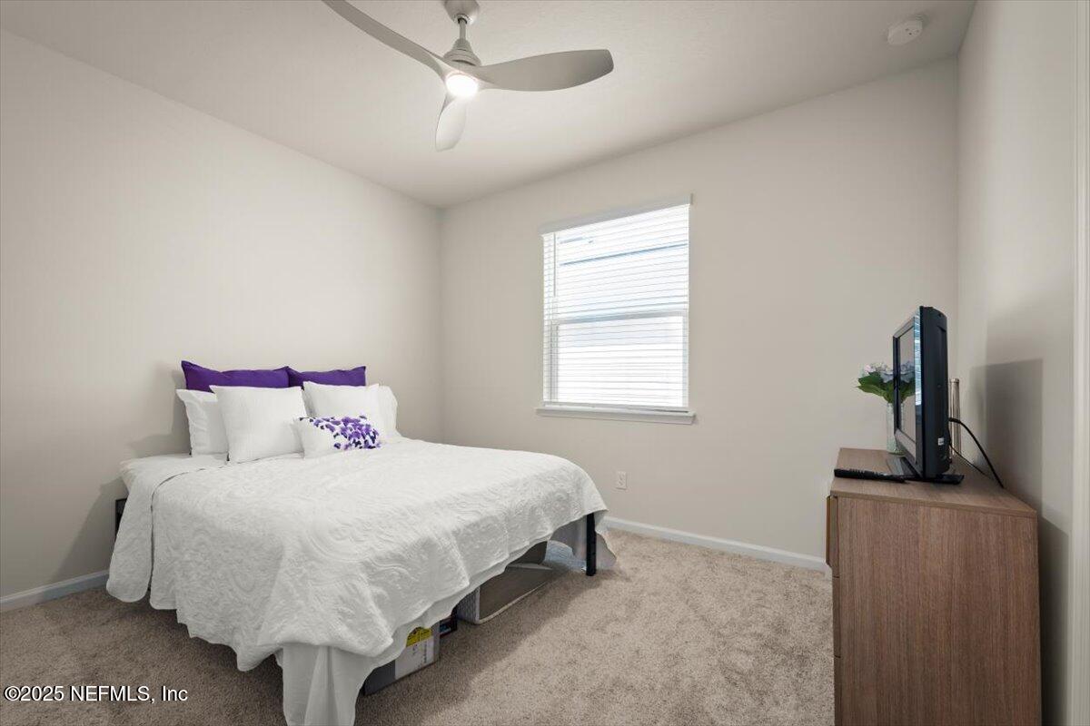 7194 Red Timber Road Jacksonville, FL 32244 - Photo 23 of 40 a bedroom with a bed and a flat tv screen