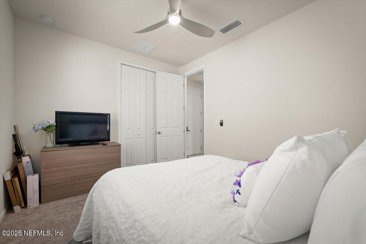 7194 Red Timber Road Jacksonville, FL 32244 - Photo 24 of 40 a bedroom with a bed and a flat screen tv