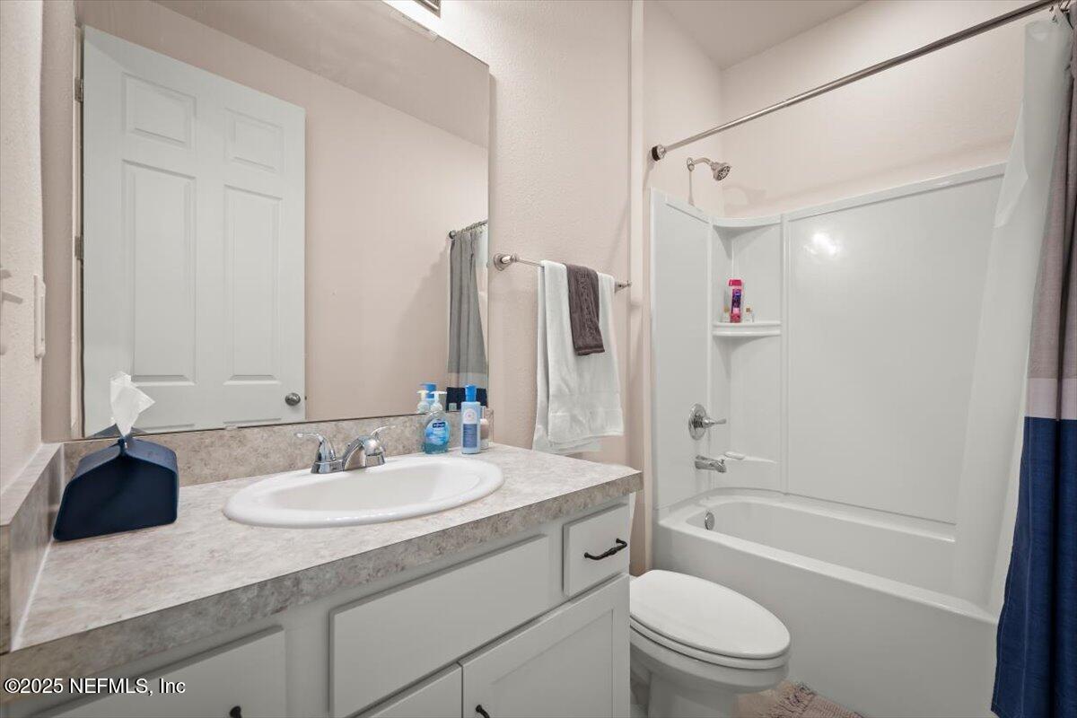 7194 Red Timber Road Jacksonville, FL 32244 - Photo 25 of 40 a bathroom with a granite countertop sink toilet and shower