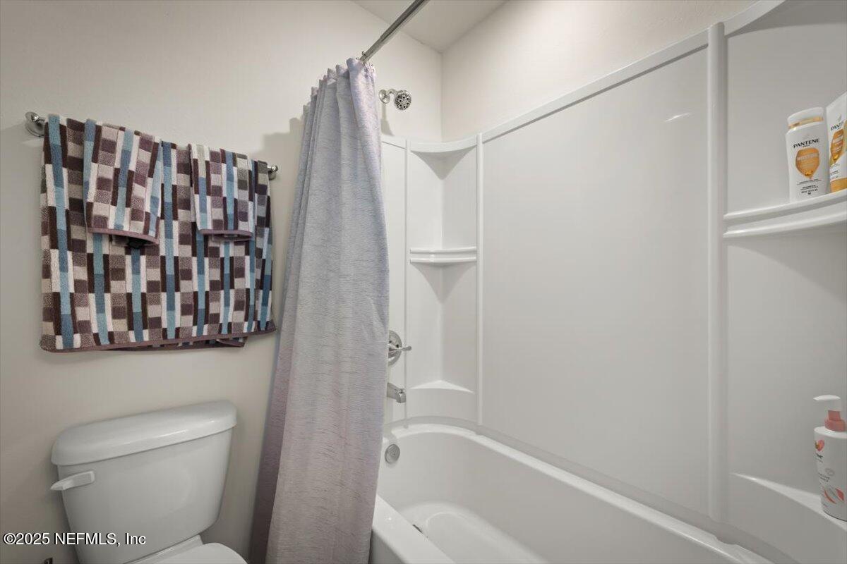 7194 Red Timber Road Jacksonville, FL 32244 - Photo 26 of 40 a bathroom with a toilet and a shower curtain