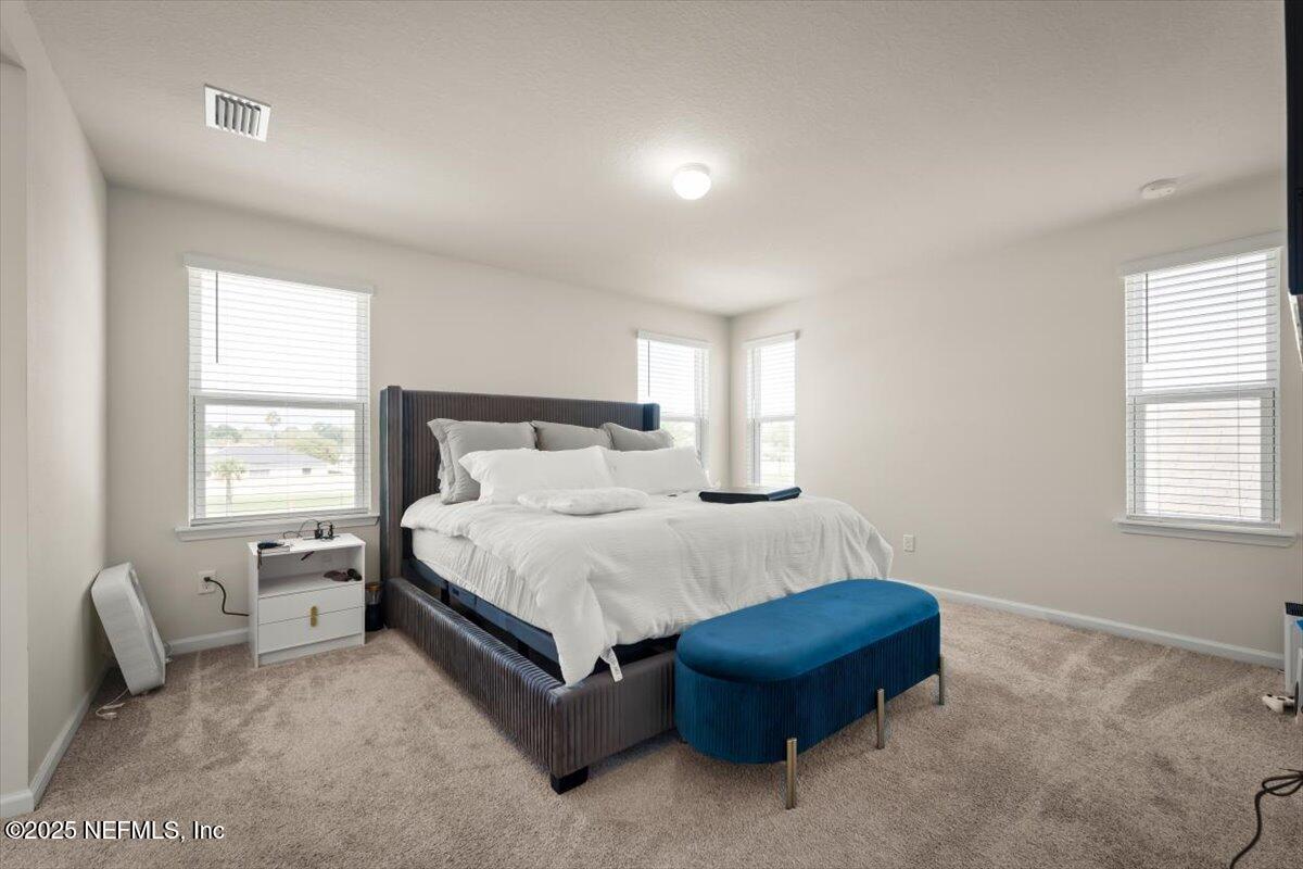 7194 Red Timber Road Jacksonville, FL 32244 - Photo 32 of 40 a bedroom with a bed a table and a window