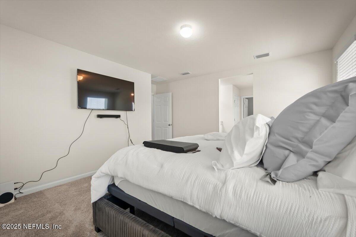 7194 Red Timber Road Jacksonville, FL 32244 - Photo 34 of 40 a bedroom with a bed and a flat screen tv