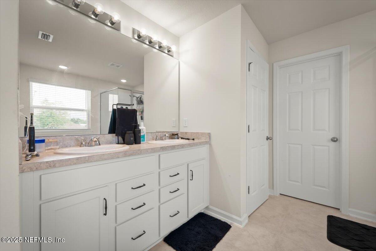 7194 Red Timber Road Jacksonville, FL 32244 - Photo 35 of 40 a bathroom with a double vanity sink and mirror with window