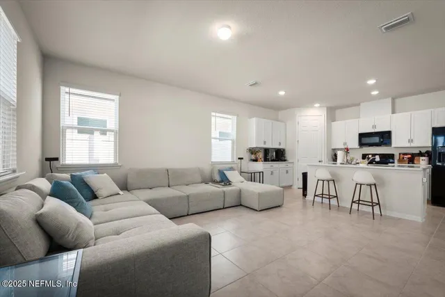 a living room with furniture and kitchen view