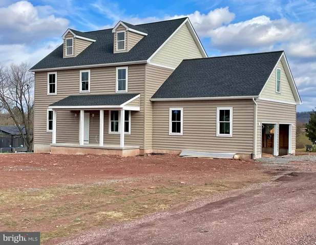 a front view of a house with a tree