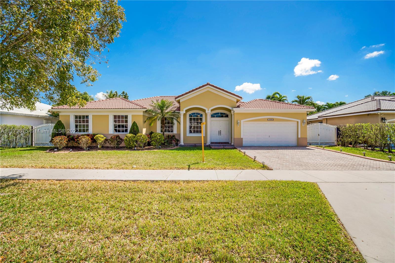 16234 Southwest 48th Terrace Miami, FL 33185 - Photo 1 of 45 a view of a white house with a large pool and lawn chairs under an umbrella