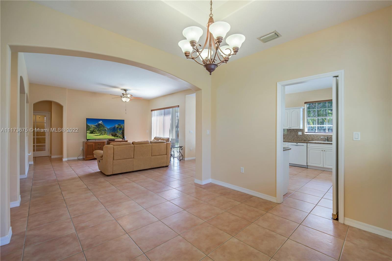 16234 Southwest 48th Terrace Miami, FL 33185 - Photo 14 of 45 a living room with furniture and a chandelier
