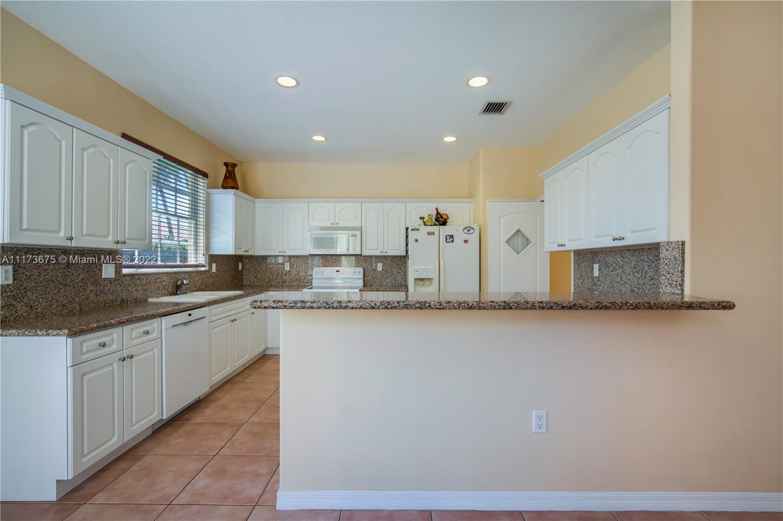 16234 Southwest 48th Terrace Miami, FL 33185 - Photo 16 of 45 a large kitchen with granite countertop a sink and dishwasher a stove top oven with wooden floor