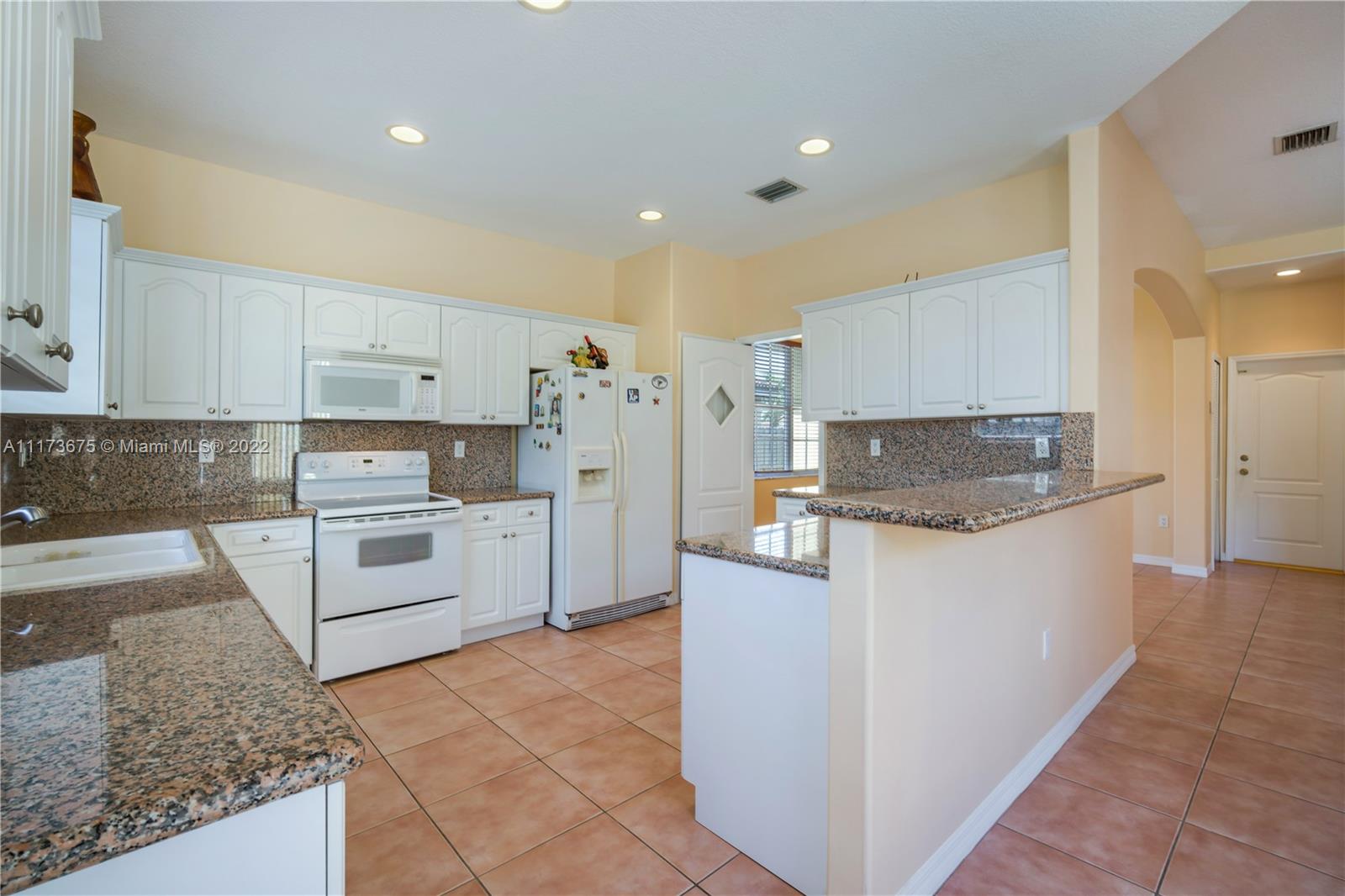 16234 Southwest 48th Terrace Miami, FL 33185 - Photo 17 of 45 a kitchen with stainless steel appliances granite countertop a stove a sink and a refrigerator