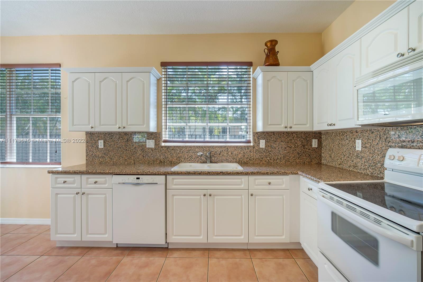 16234 Southwest 48th Terrace Miami, FL 33185 - Photo 19 of 45 a kitchen with white cabinets and window