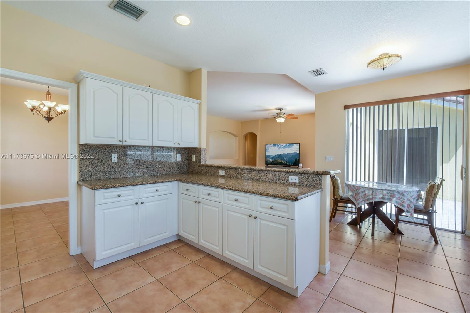 16234 Southwest 48th Terrace Miami, FL 33185 - Photo 20 of 45 a kitchen with granite countertop a sink and cabinets