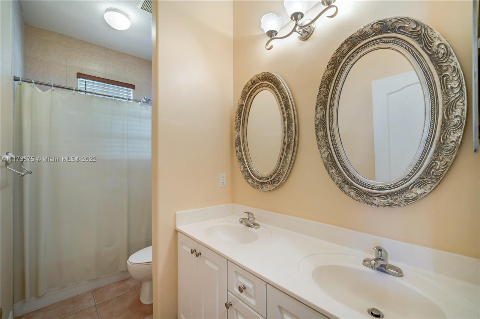 16234 Southwest 48th Terrace Miami, FL 33185 - Photo 27 of 45 a bathroom with a sink a mirror and a toilet