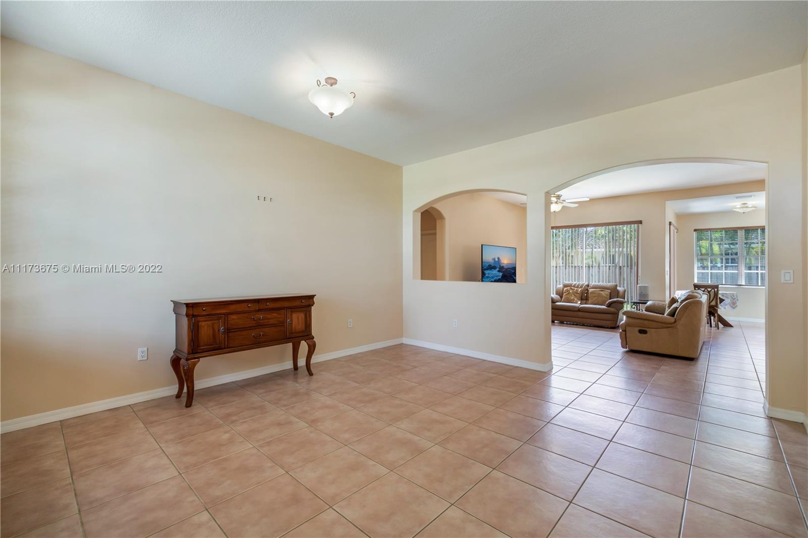 16234 Southwest 48th Terrace Miami, FL 33185 - Photo 5 of 45 a living room with furniture and a dining table with potted plant