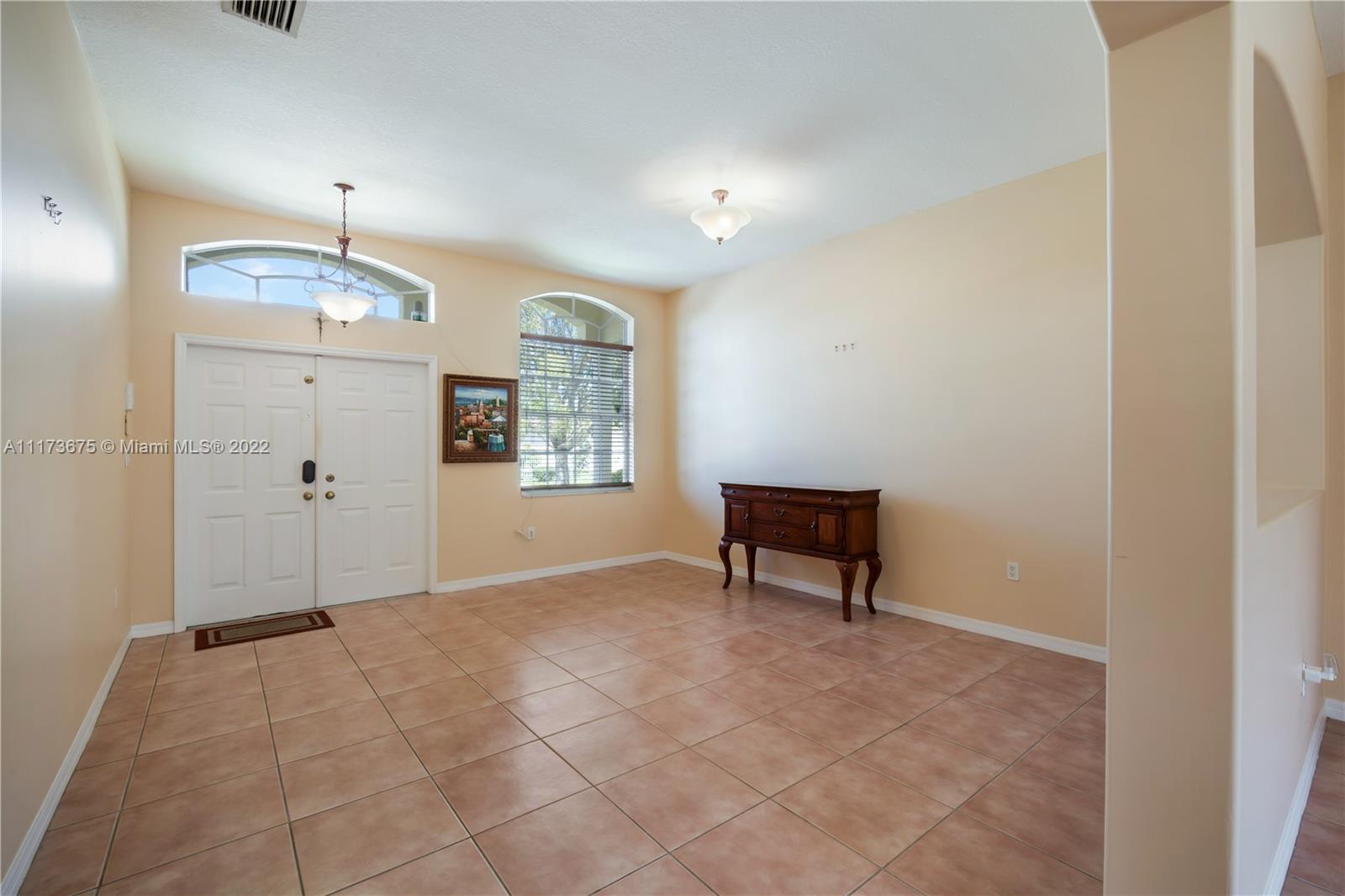 16234 Southwest 48th Terrace Miami, FL 33185 - Photo 6 of 45 an empty room with windows and a ceiling fan