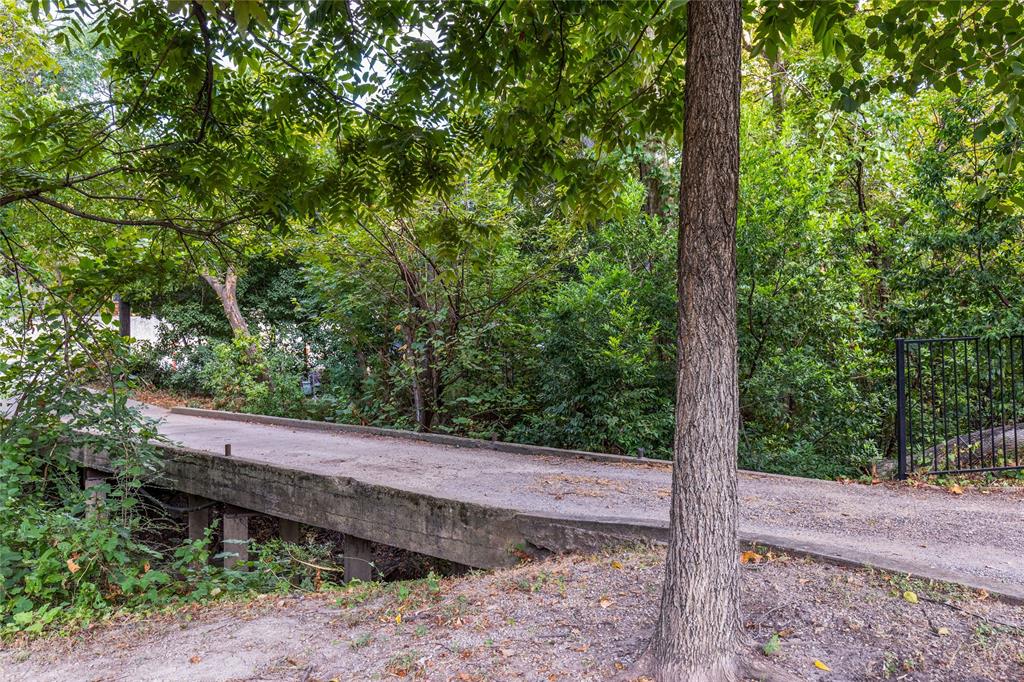 737 North Hampton Road Dallas, TX 75208 - Photo 3 of 30 The driveway crosses a bridge over the creek, creating a memorable arrival into the property.
