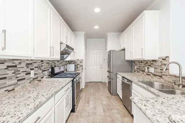 a kitchen with stainless steel appliances granite countertop a sink stove and refrigerator