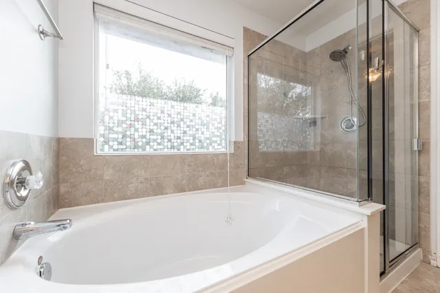 a white bath tub sitting next to a shower