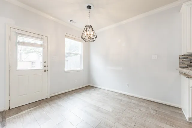 a view of empty room with wooden floor and window