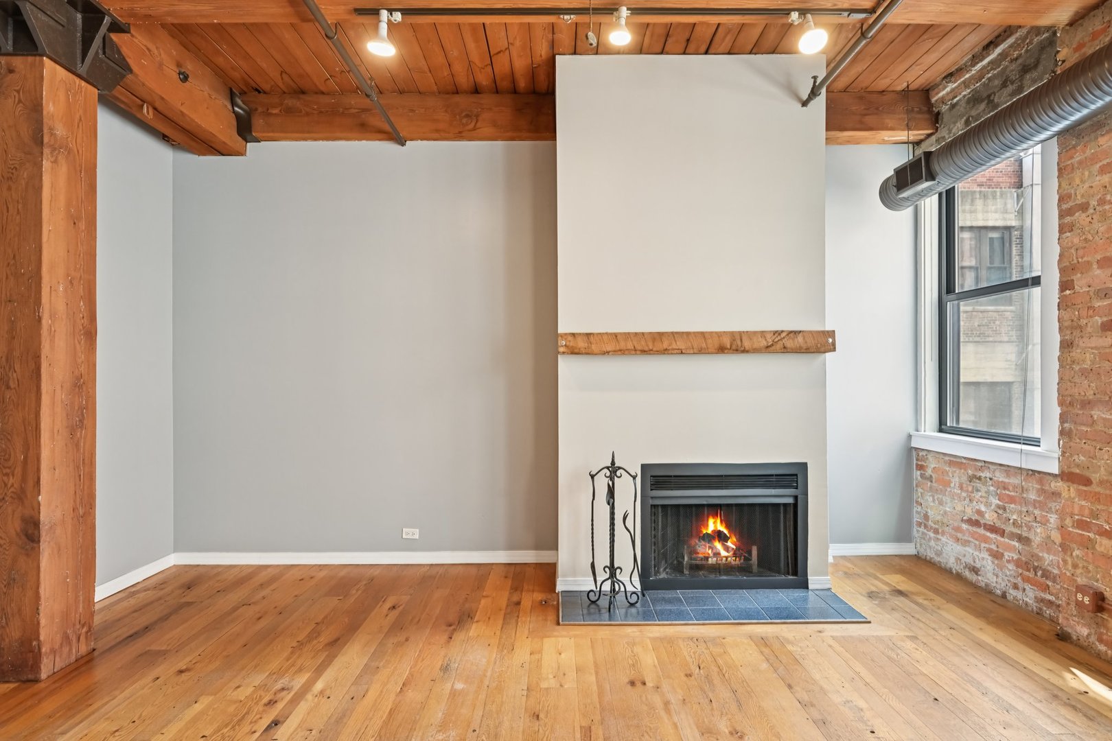 913 West Van Buren Street, Unit 5H Chicago, IL 60607 - Photo 13 of 23 a view of an empty room with wooden floor fireplace and a window