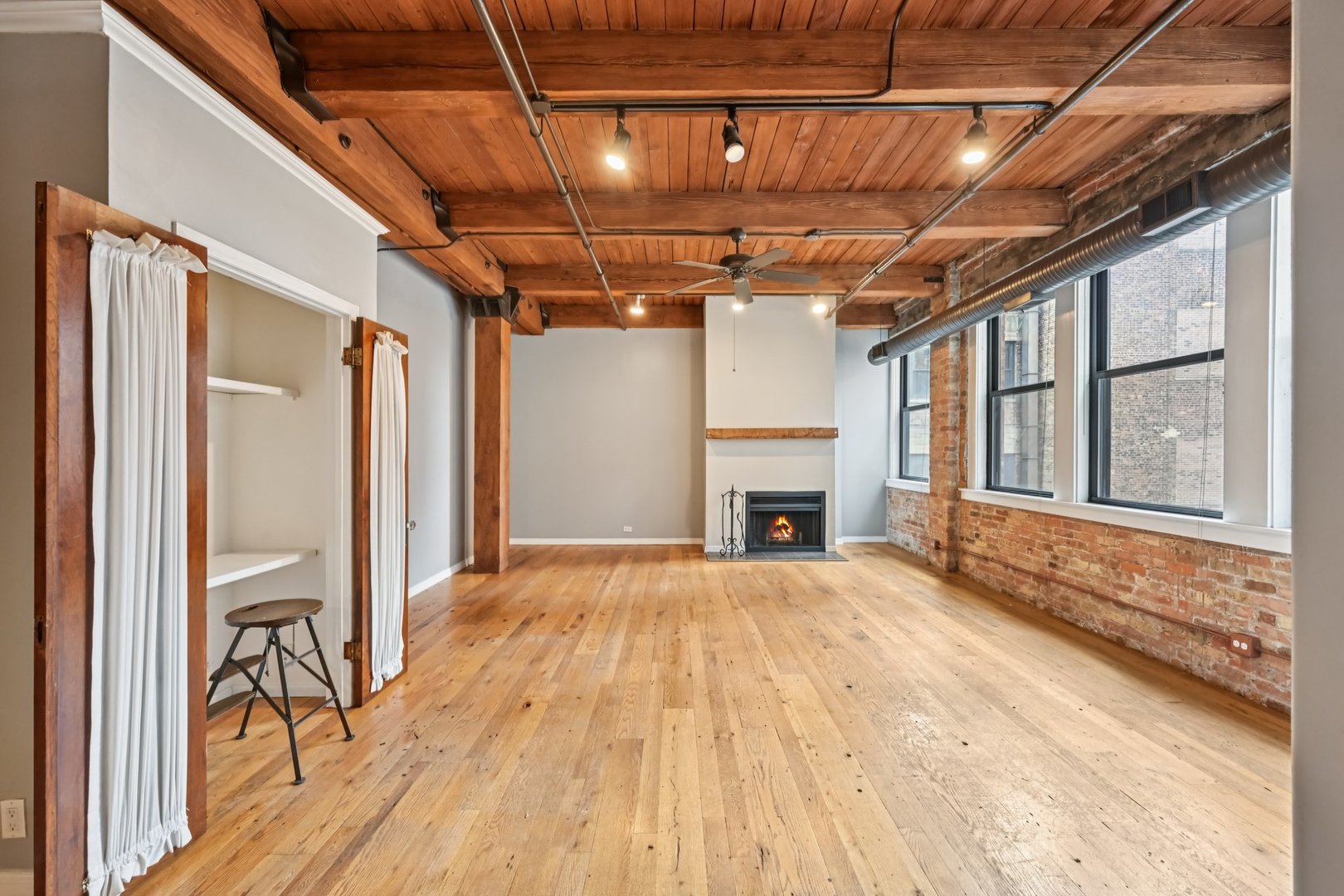 913 West Van Buren Street, Unit 5H Chicago, IL 60607 - Photo 10 of 23 a view of an empty room with wooden floor and a window