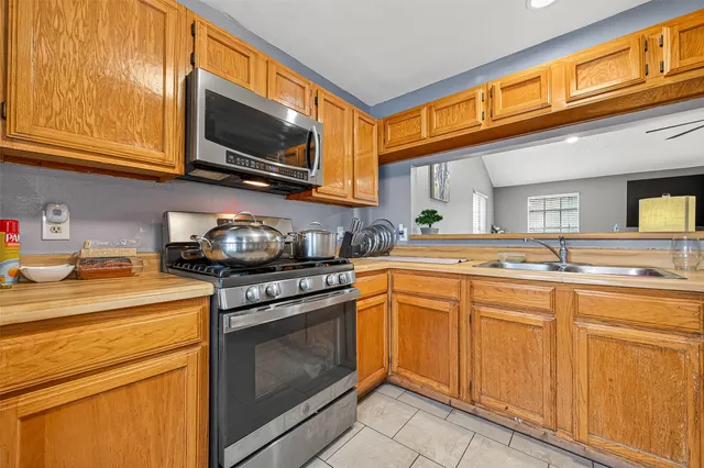 a kitchen with stainless steel appliances granite countertop a stove microwave and sink