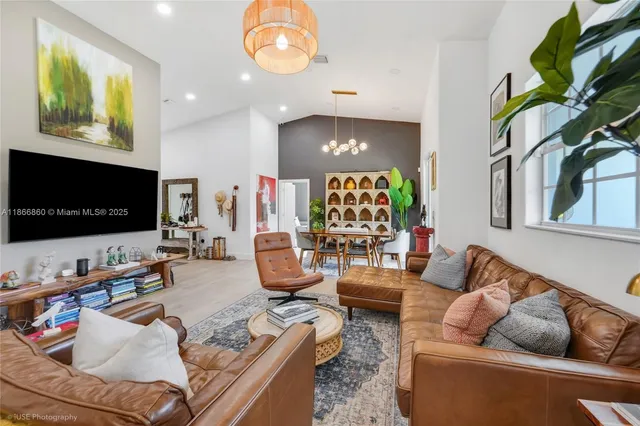 a living room with furniture chandelier and wooden floor