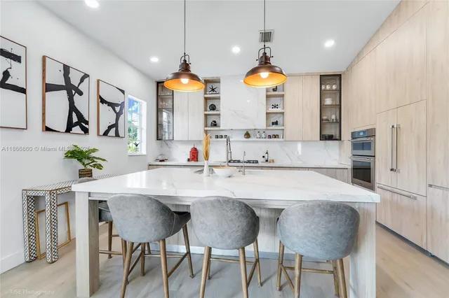 a kitchen with stainless steel appliances kitchen island granite countertop a sink a stove and cabinets