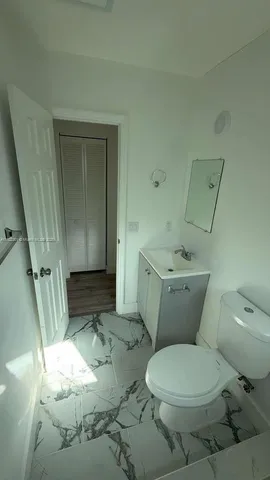 a white toilet sitting next to a sink and vanity