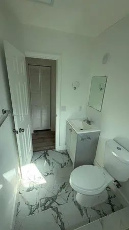 a white toilet sitting next to a sink and vanity