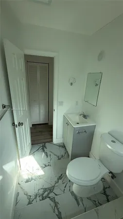a white toilet sitting next to a sink and vanity