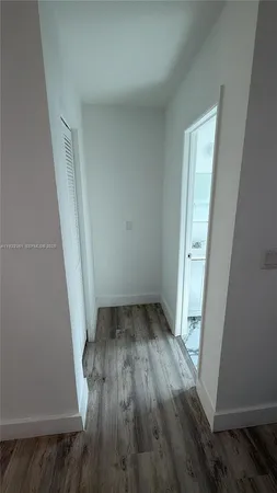 an empty room with wooden floor and white walls