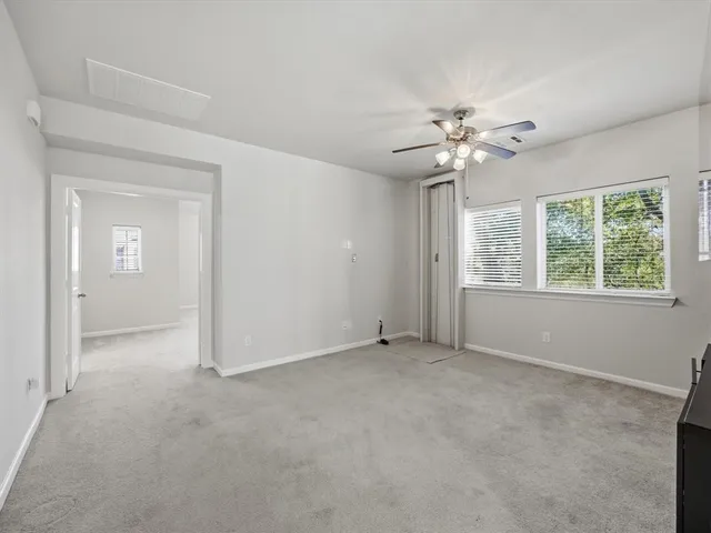 a spacious bedroom with a large bed and a chandelier