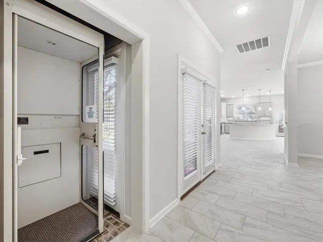 a large white kitchen with a window and stainless steel appliances