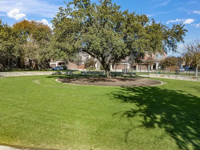 a view of a big house with a big yard and large trees