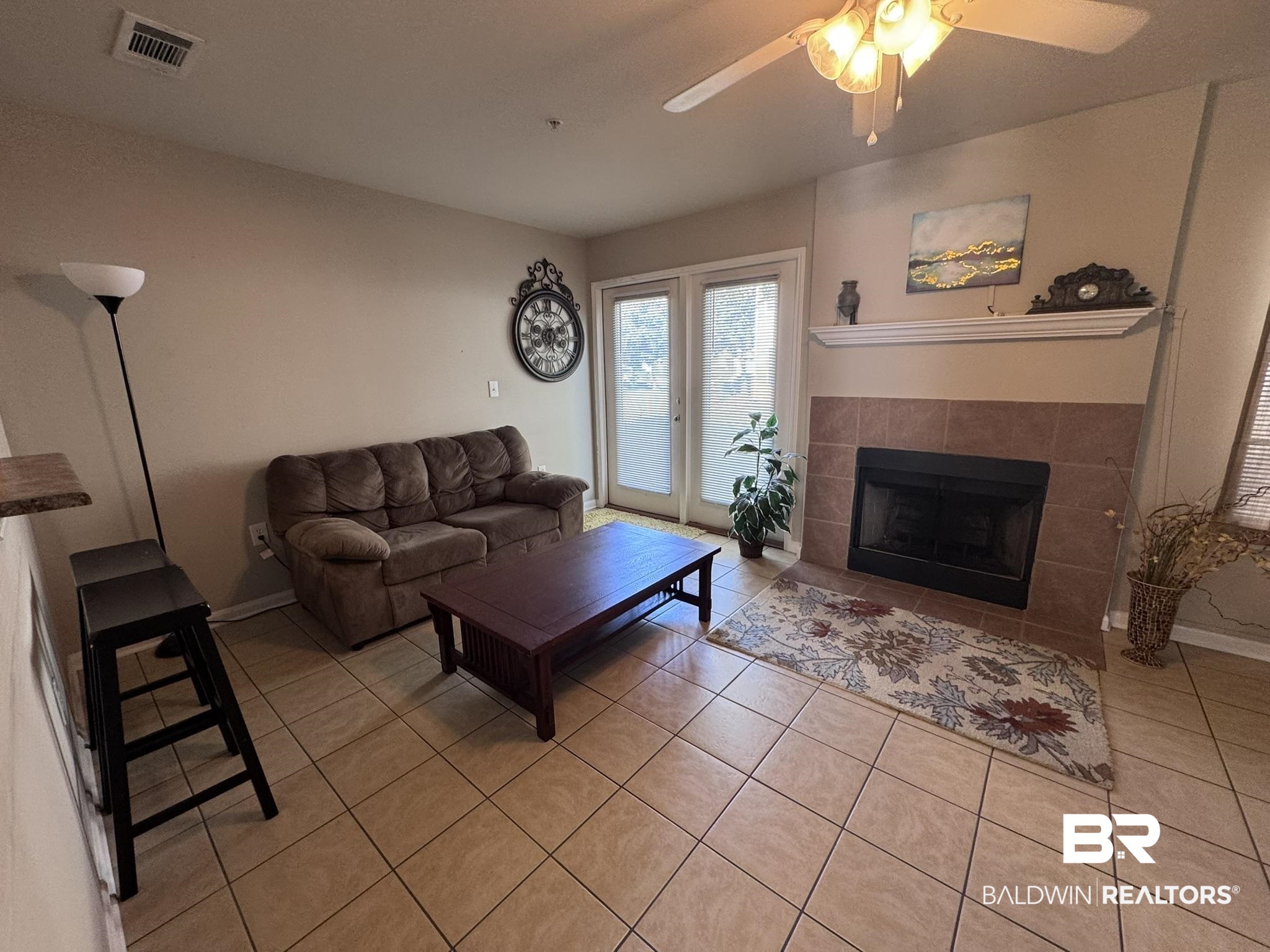 1517 Regency Road, Unit 131 Gulf Shores, AL 36542 - Photo 5 of 21 Living room featuring ceiling fan, a fireplace, and light tile patterned flooring