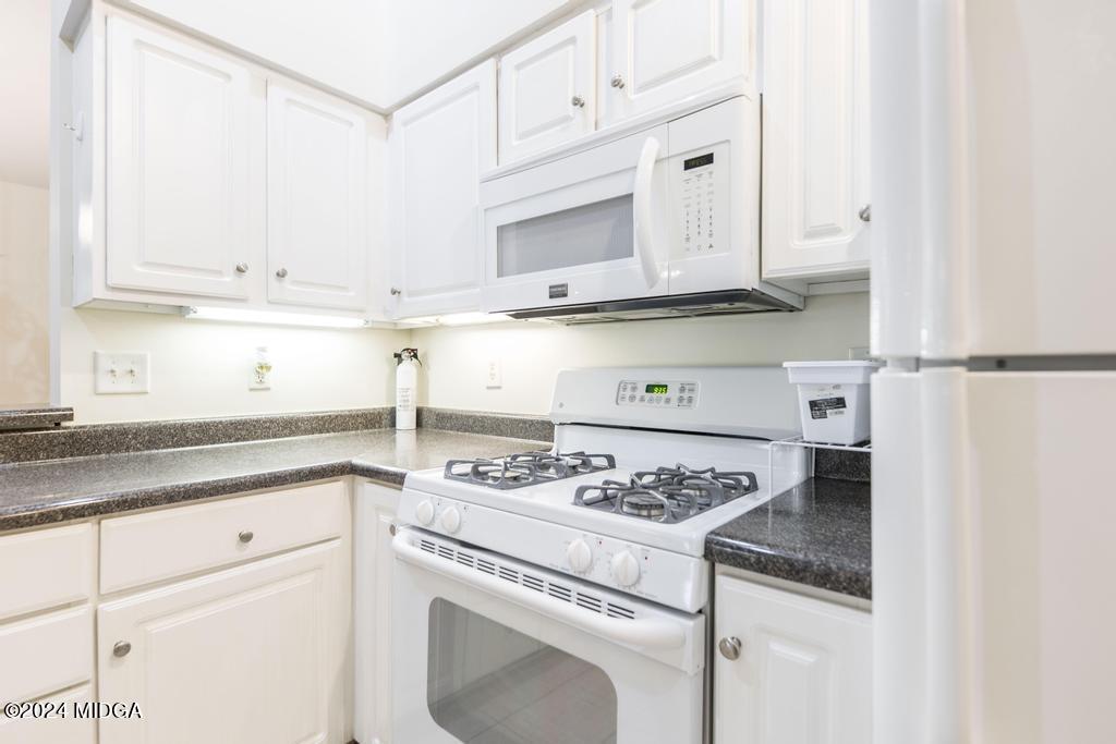 303 Cottage Lane Macon, GA 31210 - Photo 16 of 29 a kitchen with granite countertop white cabinets and white appliances