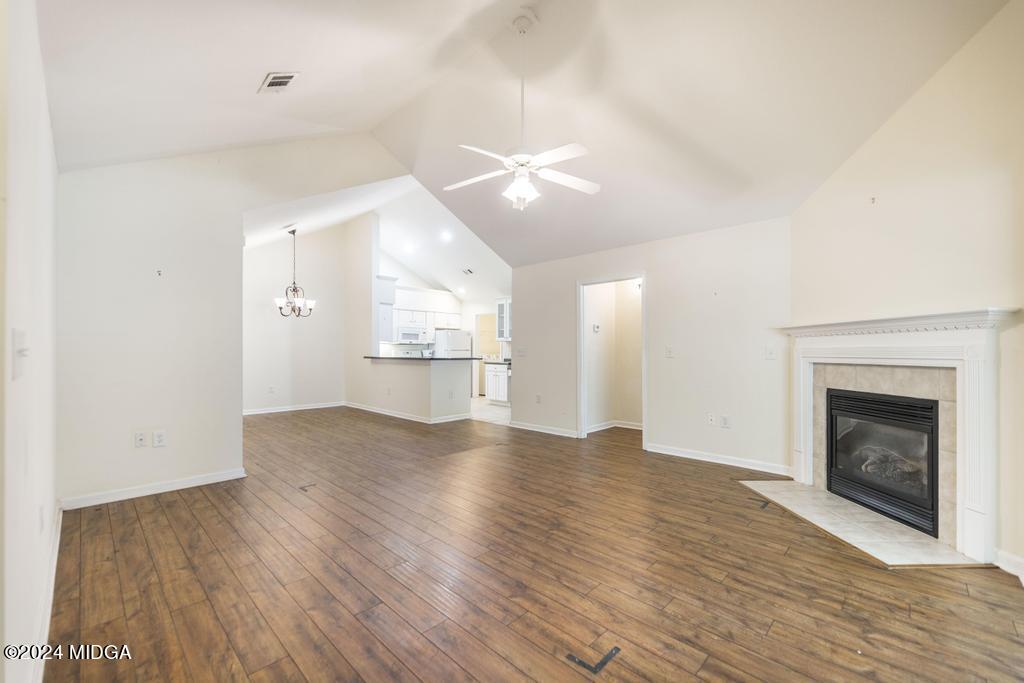 303 Cottage Lane Macon, GA 31210 - Photo 9 of 29 an empty room with wooden floor fireplace and windows