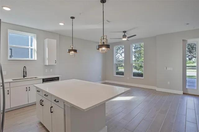 a kitchen with a stove a sink a window and wooden floor