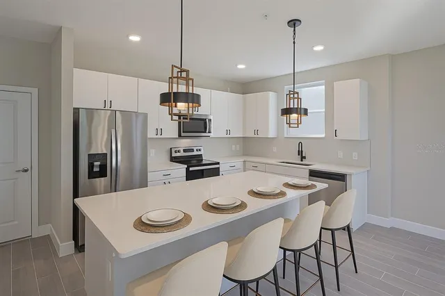 a living room with furniture kitchen view and a chandelier
