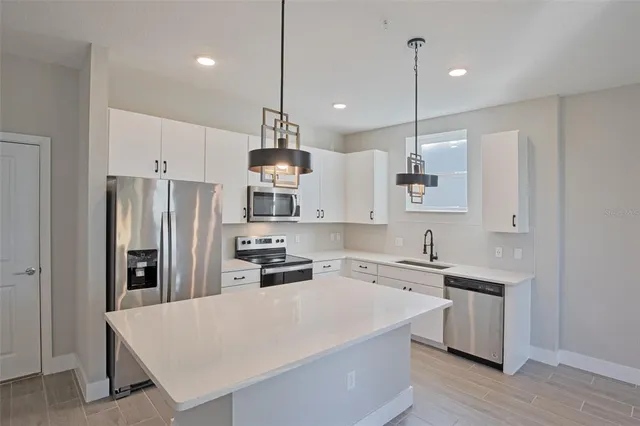 a view of kitchen with stainless steel appliances cabinets
