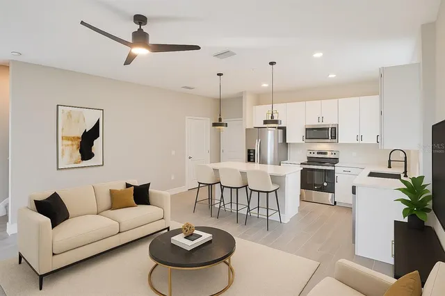a living room with furniture kitchen view and a chandelier