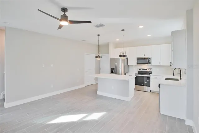 a view of kitchen with stainless steel appliances cabinets