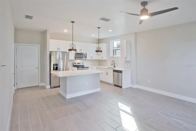 a kitchen with white cabinets and window