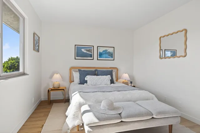 a bedroom with a bed and a painting on the wall