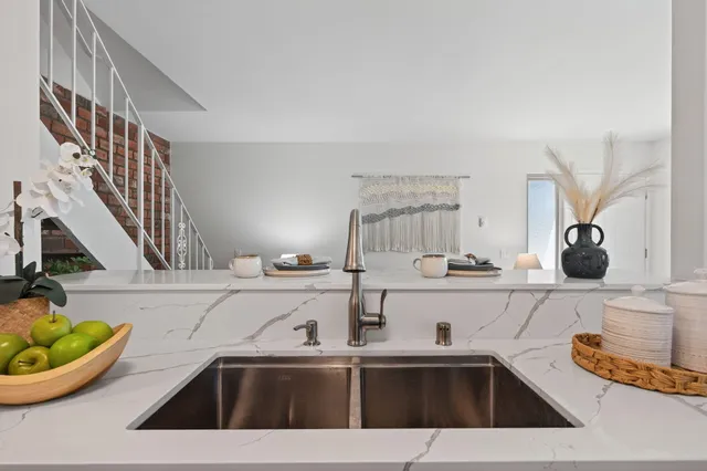 a kitchen with a sink and a stove with wooden floor