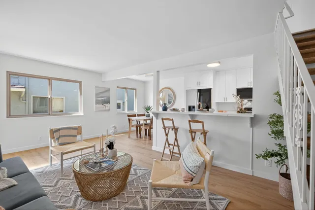 a living room with furniture a wooden floor and a dining table