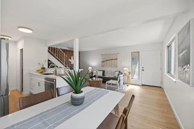 a living room with furniture a potted plant and a table