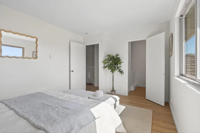 a bedroom with a bed and a potted plant