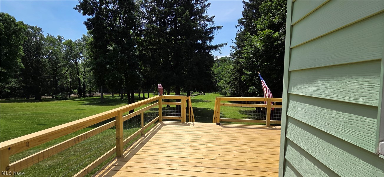9964 East River Road Elyria, OH 44035 - Photo 40 of 45 Expansive outdoor deck with natural wood decking and railings, featuring a wire mesh infill overlooking the Black River