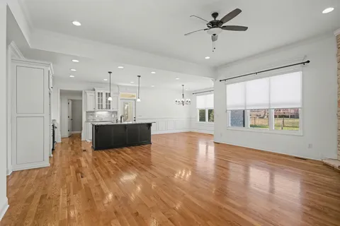 a view of kitchen with kitchen island wooden floor center island and stainless steel appliances
